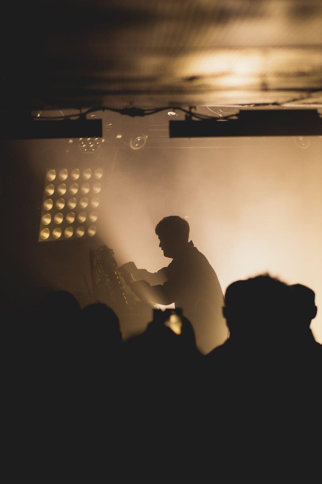 Obsimo on stage as a silhouette, lit only from behind through haze